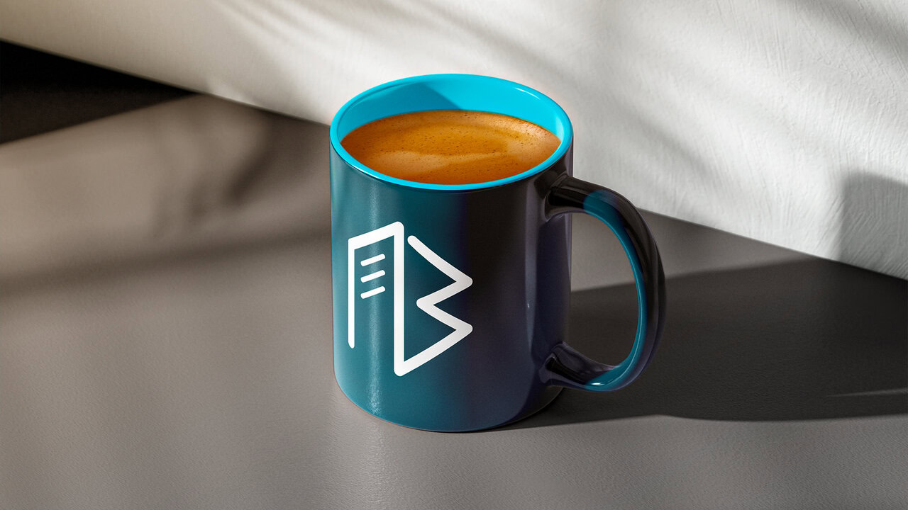 Nebly_BestInTown_Portafolio_6_1 Taza azul turquesa oscuro con el logotipo de una inmobiliaria en la ciudad de puebla, rellena de café.