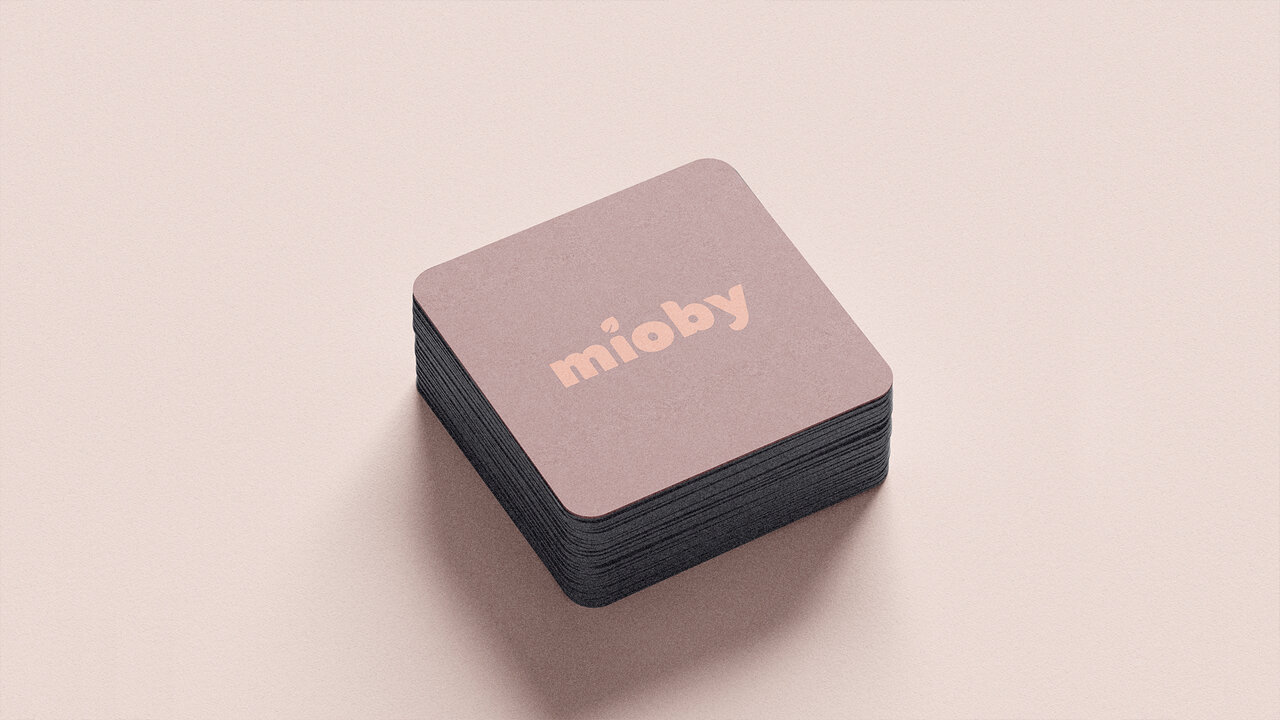 Nebly_Mioby_empaque Conjunto de tarjetas de presentación cuadradas de Mioby. Diseño en color rosa oscuro con el logotipo de la marca en color rosa claro. Papelería corporativa.