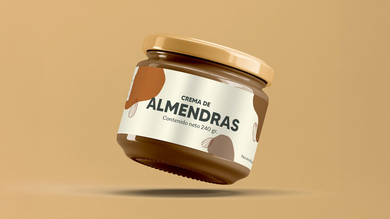 Nebly-Nekutli-Empaque Frasco de crema de almendras flotando sobre un fondo color ocre, resaltan los colores cafés y marrones.