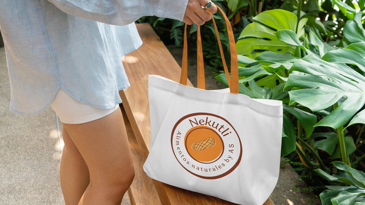 Nebly-Nekutli-ToteBag Joven mujer sosteniendo una bolsa de manta con el logotipo de una empresa de alimentos naturales.